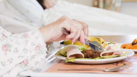 woman eating in hospital bed.png