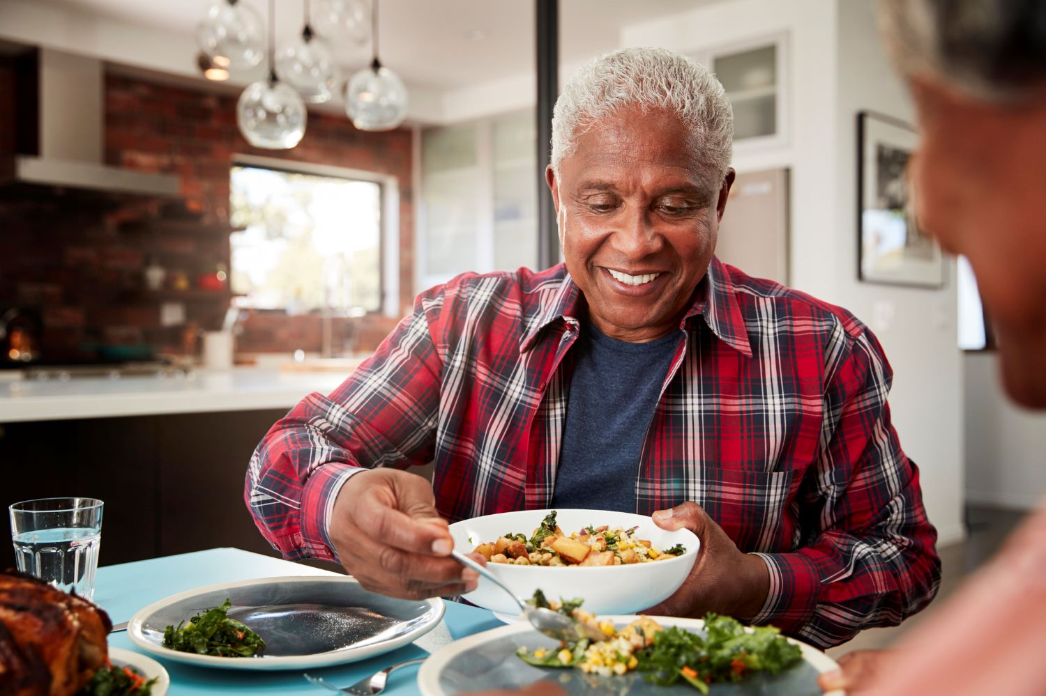 Older man eating fruit and vegetables at a table.jpg